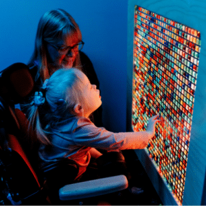 A staff member supports a child in a sensory room